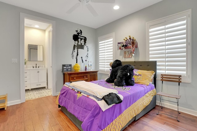 bedroom with ceiling fan, connected bathroom, and wood-type flooring