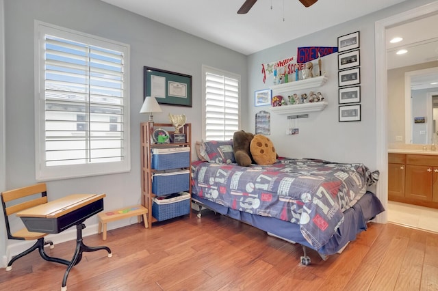 bedroom with ceiling fan, ensuite bathroom, and hardwood / wood-style floors