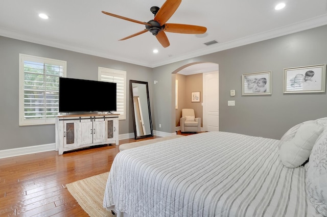 bedroom with light wood-type flooring, ceiling fan, and ornamental molding