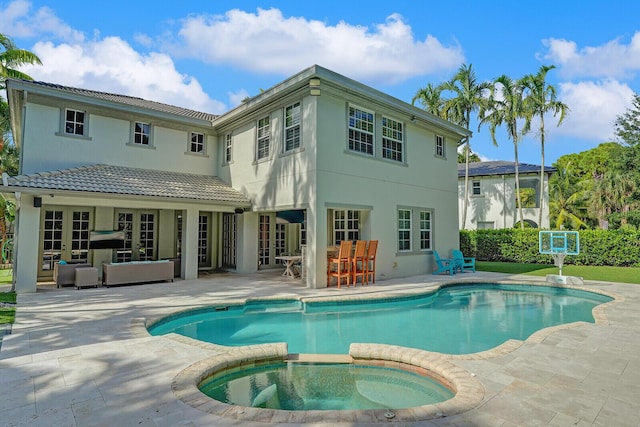 rear view of house featuring an outdoor living space, a pool with hot tub, a patio, and an outdoor bar