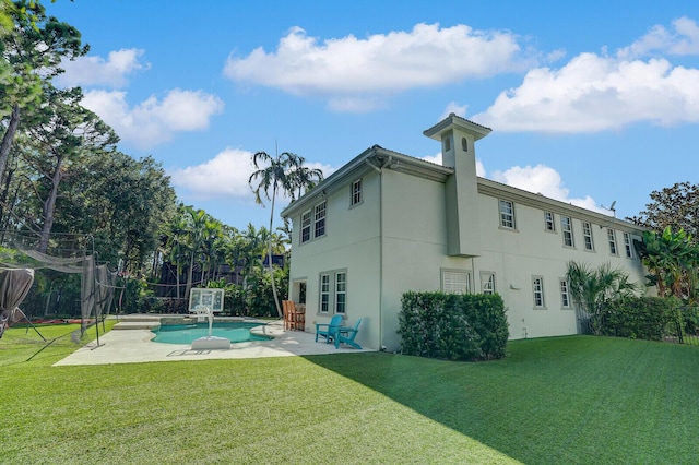 rear view of property featuring a lawn and a patio