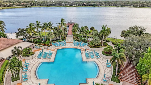 view of pool featuring a water view and a patio