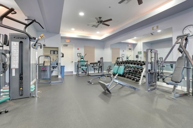 gym featuring ceiling fan and a tray ceiling