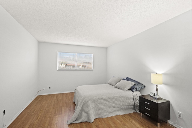 bedroom with wood-type flooring and a textured ceiling