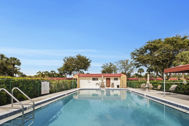 view of swimming pool featuring a patio and an outbuilding