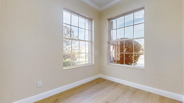 spare room featuring crown molding and light wood-type flooring