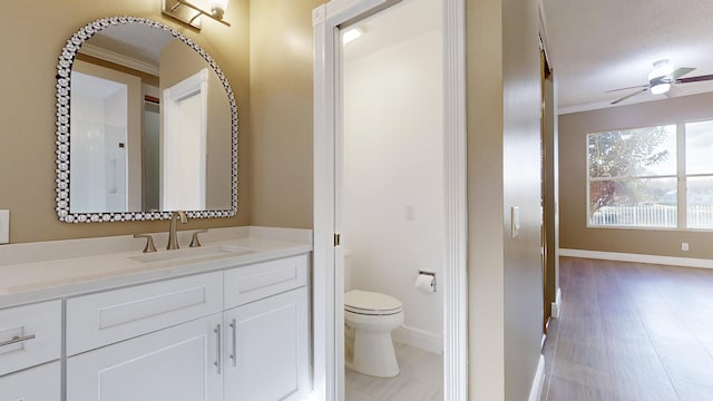 bathroom featuring vanity, ceiling fan, ornamental molding, and toilet