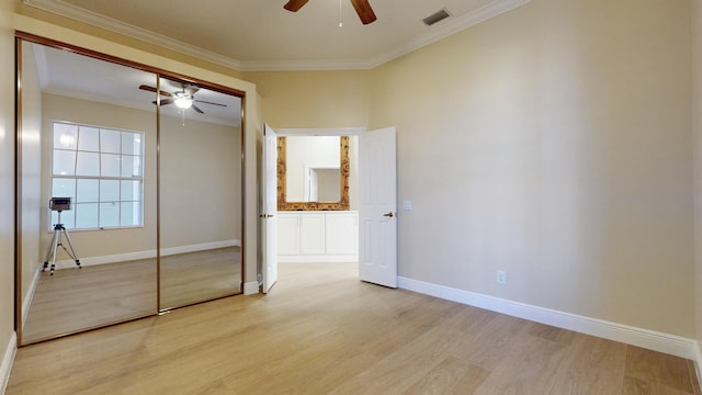 unfurnished bedroom with ornamental molding, ceiling fan, light hardwood / wood-style floors, and a closet