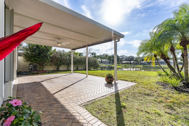 view of patio / terrace with a water view, central AC unit, and ceiling fan