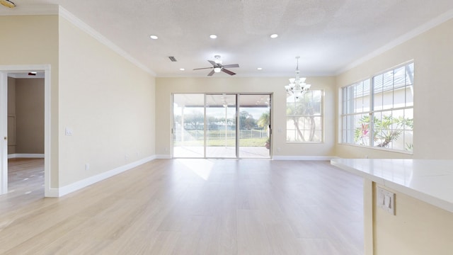 unfurnished living room with crown molding, a healthy amount of sunlight, ceiling fan with notable chandelier, and light hardwood / wood-style flooring