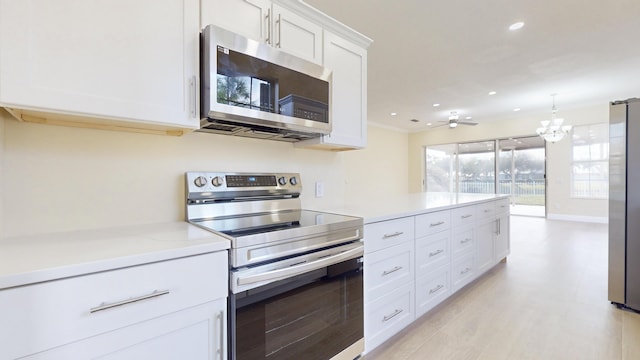 kitchen with white cabinetry, light stone counters, appliances with stainless steel finishes, pendant lighting, and ceiling fan