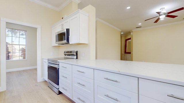 kitchen featuring crown molding, light hardwood / wood-style flooring, stainless steel appliances, light stone counters, and white cabinets