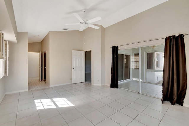 empty room featuring light tile patterned flooring, high vaulted ceiling, and ceiling fan