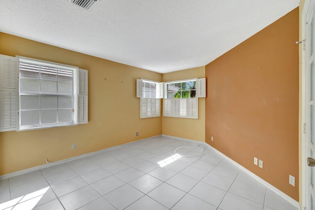 tiled spare room with a textured ceiling