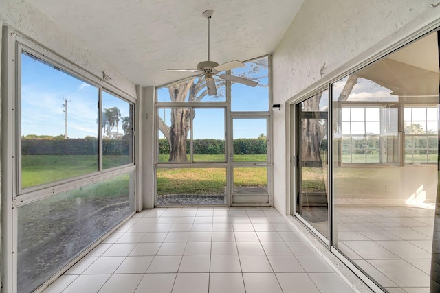 unfurnished sunroom featuring ceiling fan and a healthy amount of sunlight