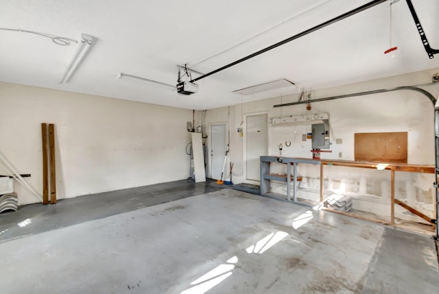 garage with a garage door opener, electric panel, and a workshop area