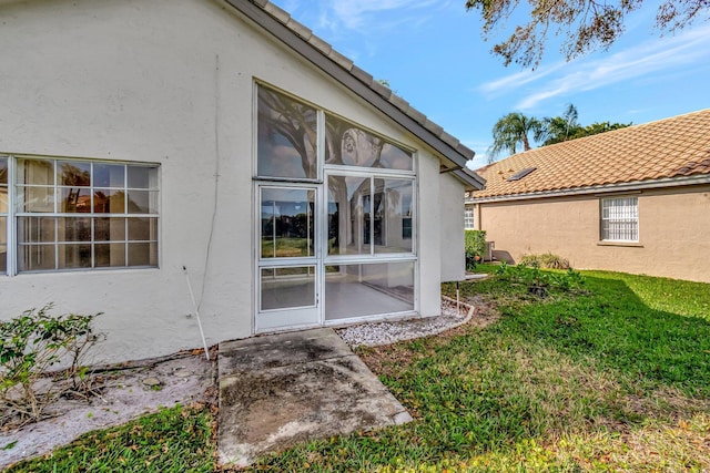 back of house featuring a sunroom and a yard