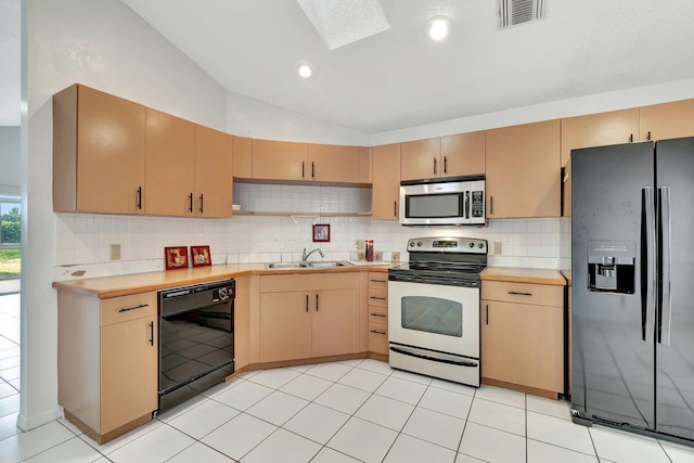 kitchen featuring light brown cabinetry, sink, black appliances, and vaulted ceiling with skylight