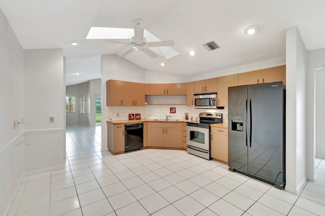 kitchen featuring lofted ceiling with skylight, light brown cabinetry, sink, light tile patterned floors, and black appliances