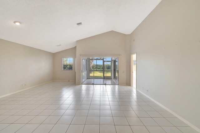 spare room with high vaulted ceiling and light tile patterned flooring