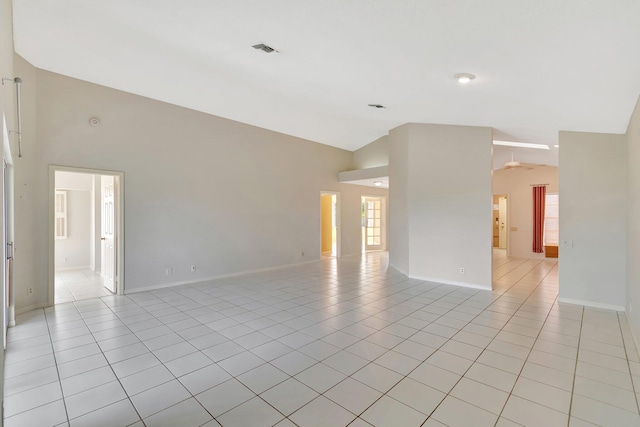 tiled spare room featuring high vaulted ceiling