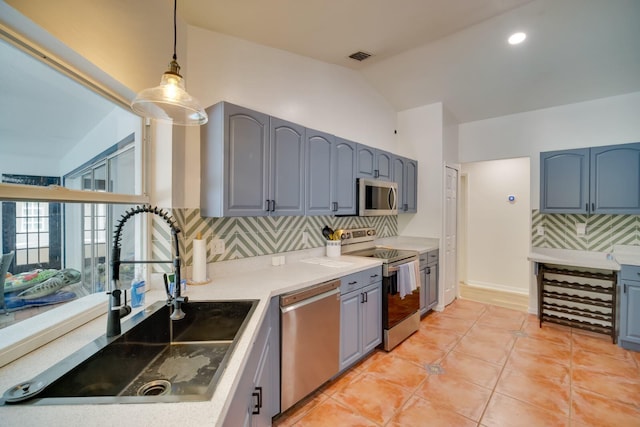 kitchen with stainless steel appliances, a sink, visible vents, gray cabinets, and decorative backsplash