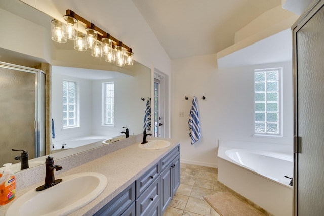 bathroom featuring a garden tub, double vanity, a stall shower, and a sink