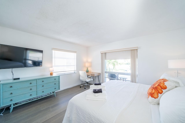 bedroom featuring dark hardwood / wood-style floors, a textured ceiling, and multiple windows