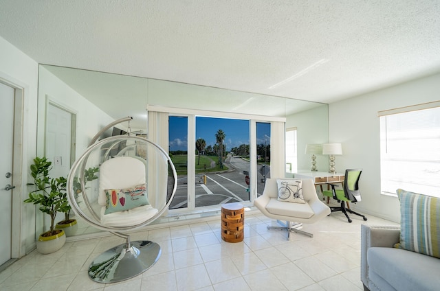 living area with a textured ceiling and light tile patterned floors