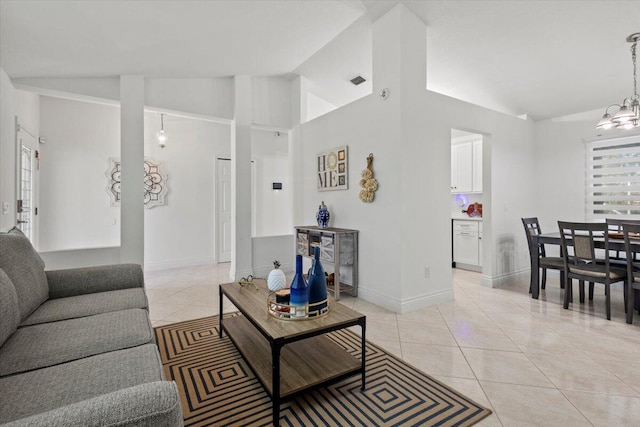 living room featuring an inviting chandelier, high vaulted ceiling, and light tile patterned floors