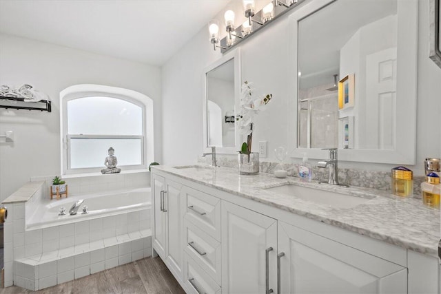 bathroom featuring vanity, hardwood / wood-style flooring, and plus walk in shower