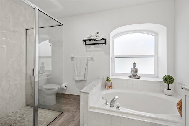 bathroom featuring separate shower and tub and toilet