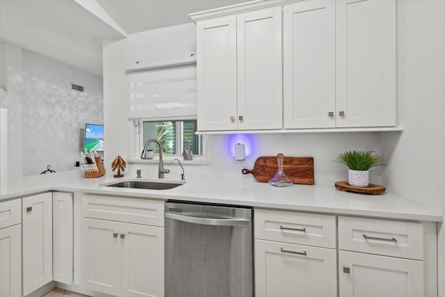 kitchen with light stone counters, dishwasher, sink, and white cabinets