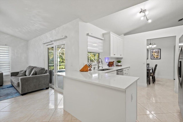 kitchen with lofted ceiling, sink, white cabinets, light tile patterned floors, and kitchen peninsula