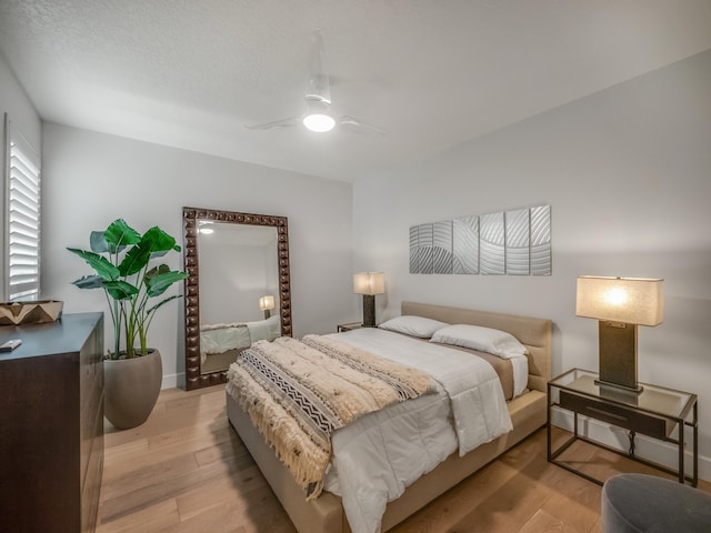 bedroom with ceiling fan and light hardwood / wood-style floors