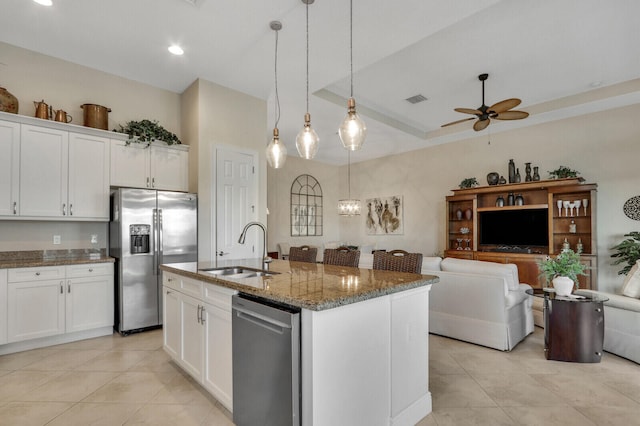 kitchen featuring sink, white cabinetry, a center island with sink, dark stone countertops, and appliances with stainless steel finishes