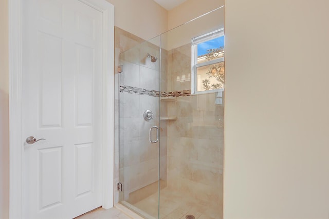 bathroom with a shower with door