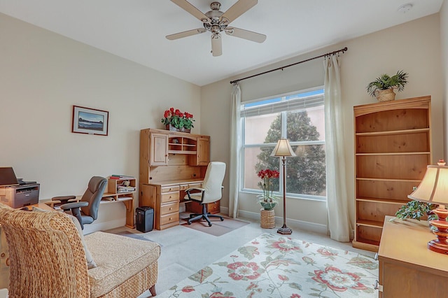 carpeted office space featuring ceiling fan