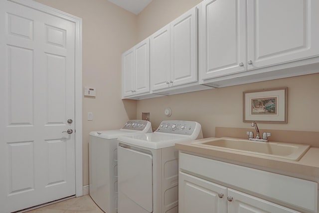 laundry area featuring light tile patterned flooring, cabinets, sink, and washing machine and dryer