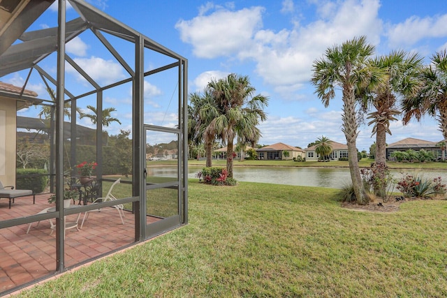 view of yard with a patio, a water view, and glass enclosure