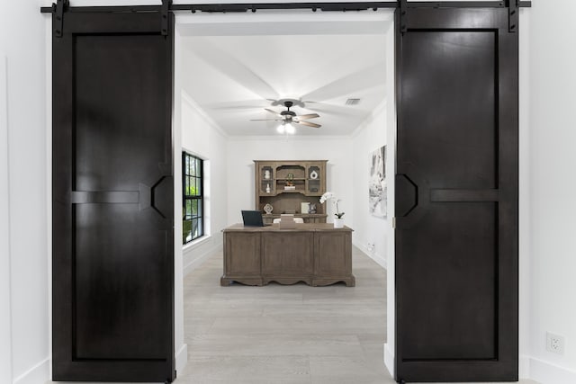 kitchen with light hardwood / wood-style floors, ceiling fan, crown molding, and a barn door