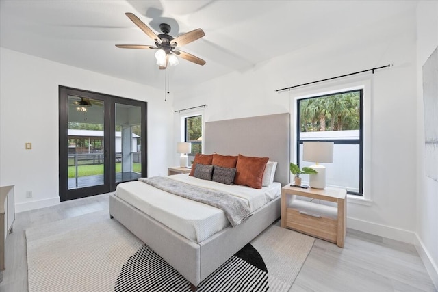 bedroom featuring multiple windows, access to exterior, ceiling fan, and light hardwood / wood-style floors