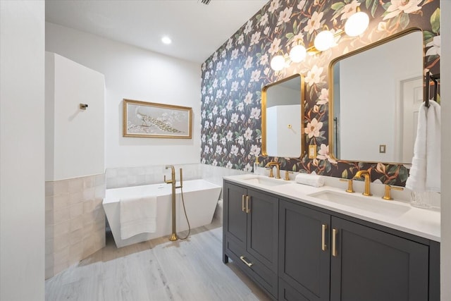 bathroom featuring hardwood / wood-style flooring, a tub to relax in, and vanity