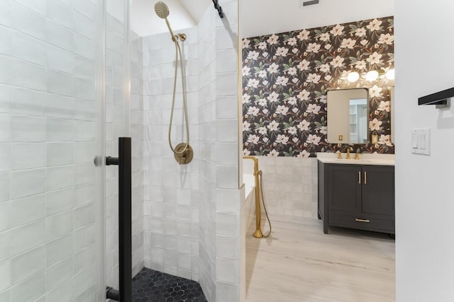 bathroom with tiled shower and vanity