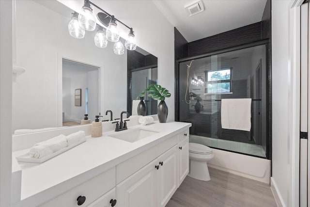 full bathroom with vanity, toilet, combined bath / shower with glass door, and wood-type flooring