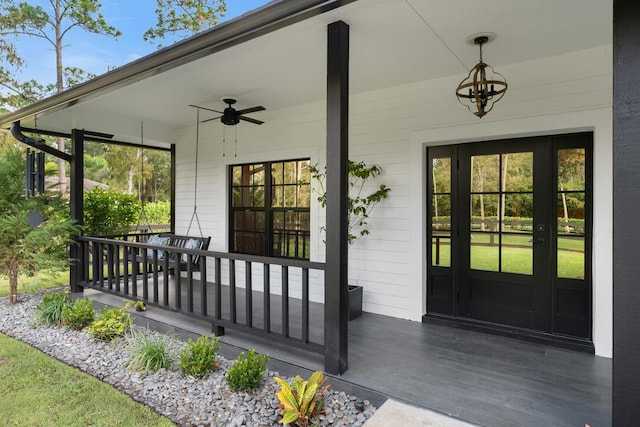 view of exterior entry featuring a porch and ceiling fan