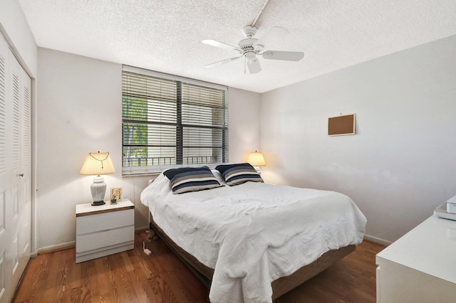 27 Abbey Ln Unit 205, Delray Beach, FL 33446 - bedroom featuring dark wood-type flooring, a textured ceiling, ceiling fan, and a closet