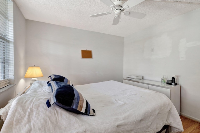 27 Abbey Ln Unit 205, Delray Beach, FL 33446 - bedroom featuring multiple windows, ceiling fan, a textured ceiling, and light wood-type flooring