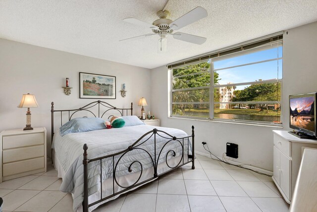 27 Abbey Ln Unit 205, Delray Beach, FL 33446 - bedroom with ceiling fan, light tile patterned floors, and a textured ceiling