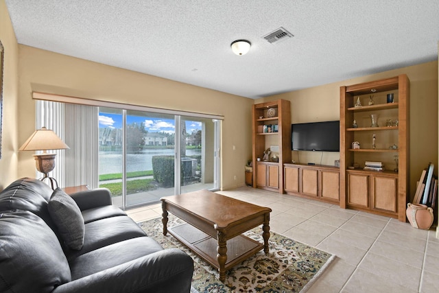 living room featuring light tile patterned flooring and a textured ceiling